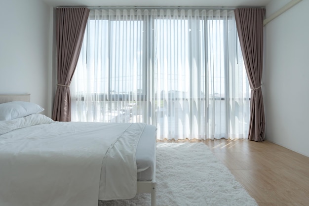 White bedroom with white curtains and white pillows