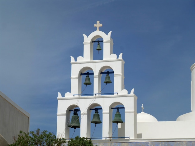 Foto campanile bianco di una chiesa e di un cielo blu, isola di santorini, grecia