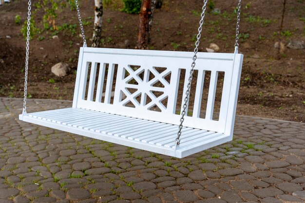 White benchswing on chains in the park