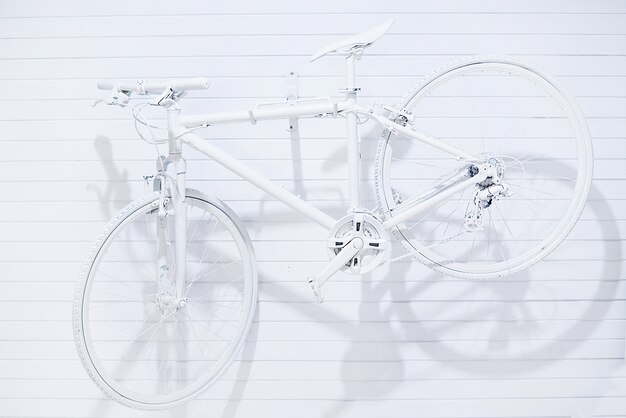 Photo white bicycle hanging on white wall