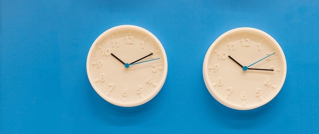 Bianco grande orologio da parete analogico semplice su sfondo blu pastello alla moda copia spazio gestione del tempo conc