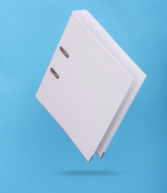 white binder with rings levitating on blue background