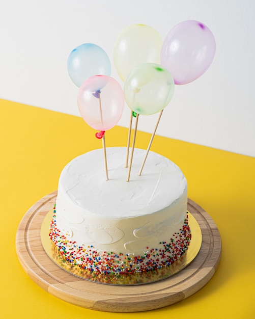 White Birthday cake and colorful balloons