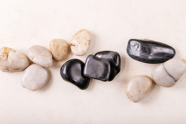 Фото Белые, черные декоративные камни и галька на серой деревянной поверхности. креативный макет