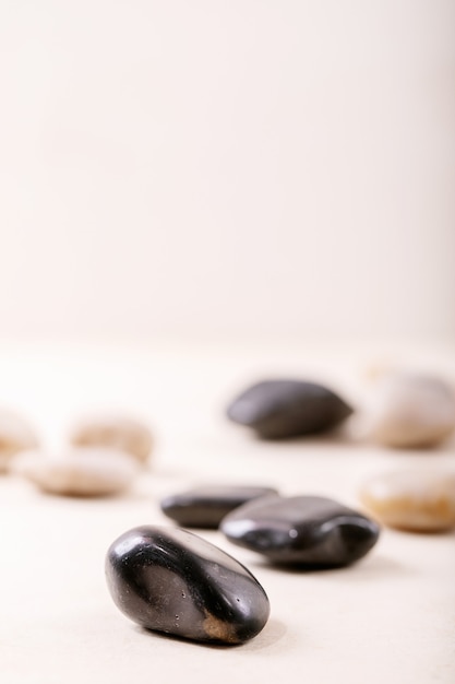 Photo white, black decorative rocks and pebbles over grey wooden wall