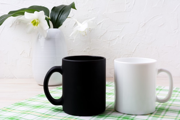 Photo white and black mug mockup with lily in vase