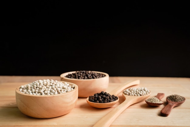 Pepe bianco e nero in una tazza con fondo di venature del legno, concetto industriale