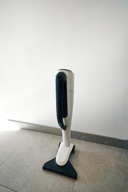 A white and black vacuum cleaner with a green logo on the bottom.