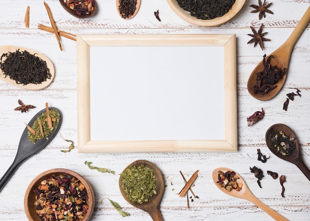 White blank board surrounded with herbs on white textured backdrop