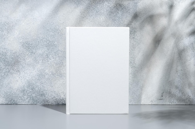 White blank book with hard cover on gray background with shadows