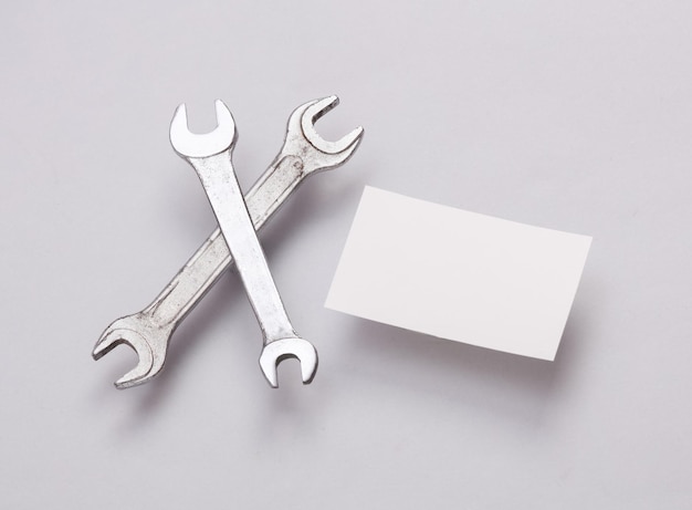 white blank business cards for branding and wrench on gray background creative mockup for presentations and corporate identity