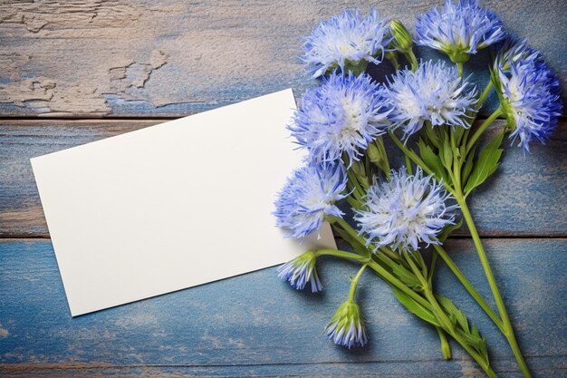 Photo white blank card on cornflowers with copy space