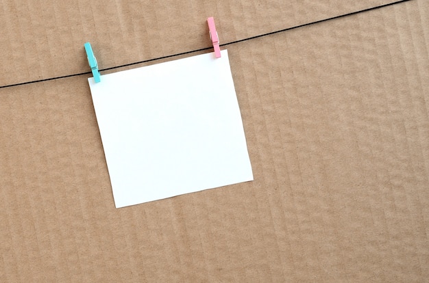 White blank card on rope on a brown cardboard background