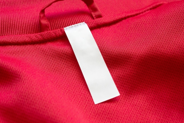 White blank clothes label on red jersey texture background