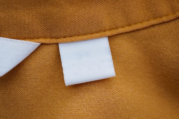 White blank clothing label on brown shirt background