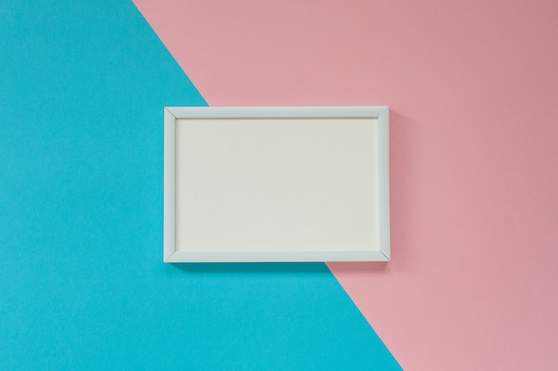 white blank frame on blue and pink  for mockup. flat lay