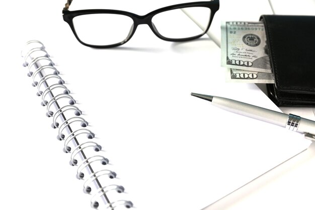 White blank notebook with silver pen and glasses