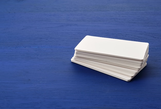 White blank paper rectangular business cards on blue wooden background