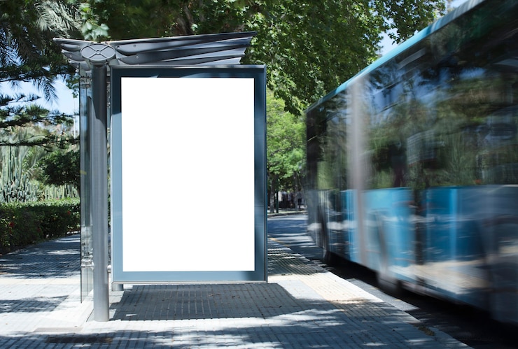 Photo white blank vertical billboard at the bus stop on the city street in the background of buses and ro