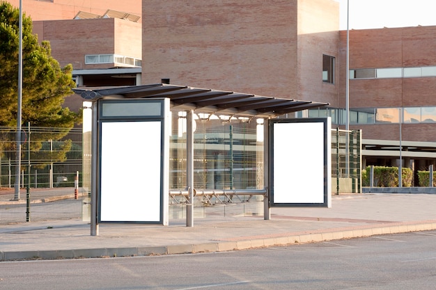 White blank vertical billboard at the bus stop on the city street Sign on the street by the side of