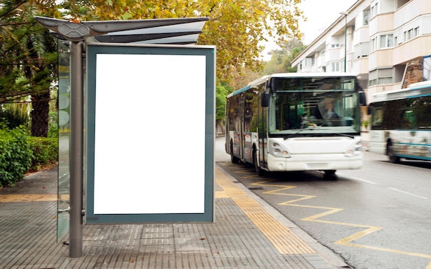 White blank vertical billboard at the bus stop on the city street