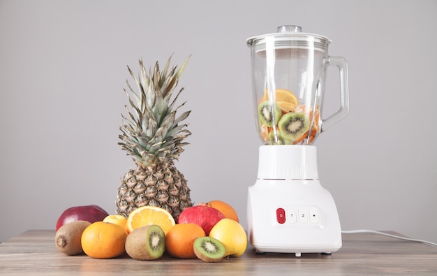 Photo white blender with fresh fruits on the table.