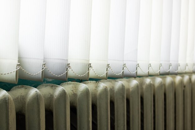 White blinds on the window above the radiator