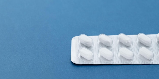 White blister pills on a blue background