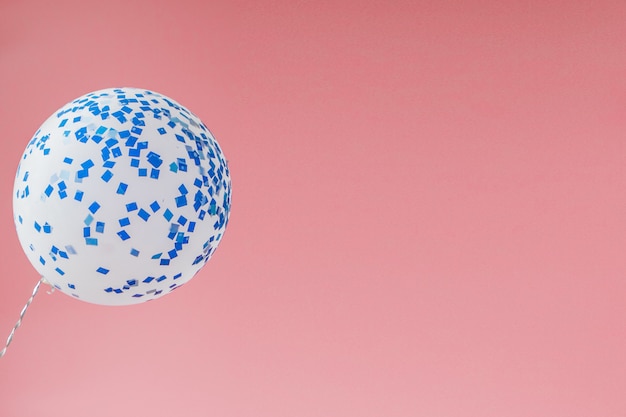 Photo white and blue balloon on a pink background