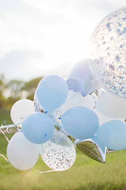 White and blue balloons with confetti Birthday balloons outdoor at sunlight