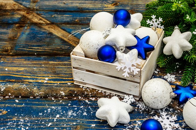 White and blue Christmas balls and stars, fir tree branches and snowflakes. copy space