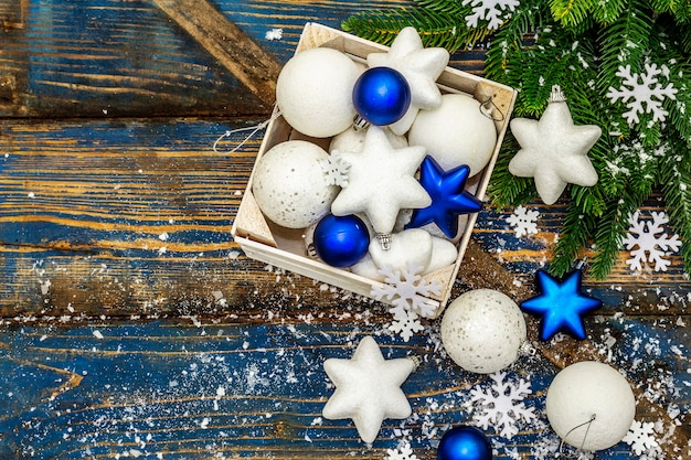 Palle e stelle di natale bianche e blu, rami di abete e fiocchi di neve. vista dall'alto