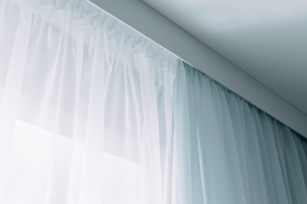 天井の棚の白と青のカーテンリビングルームのカーテンの室内装飾屋内
