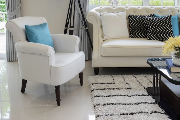 White and blue pillows on a white leather couch in vintage living room