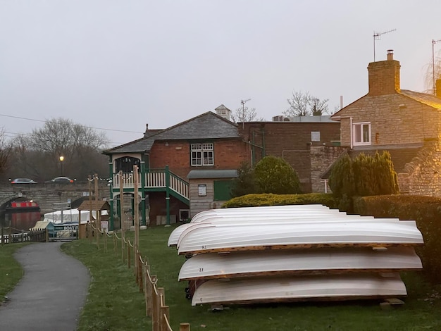 White boats stacked on the grass near the river