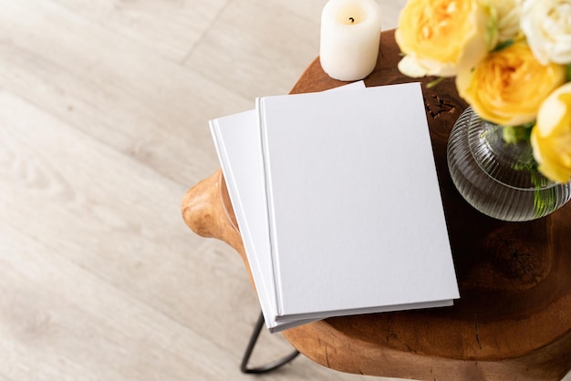 Mockup di copertina in bianco del libro bianco su un elegante tavolino da caffè in legno con vista ad alto angolo di bouquet di rose