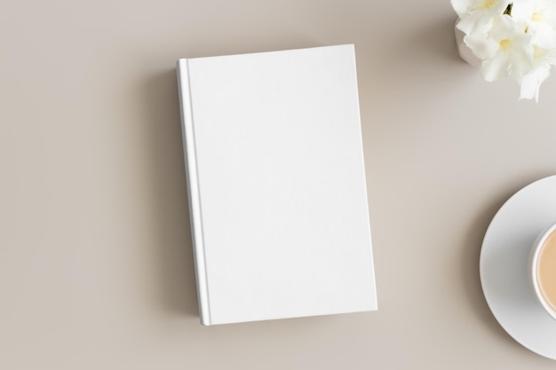사진 베이지색 테이블에 커피 한 잔과 서양 협죽도가 있는 흰색 책 모형