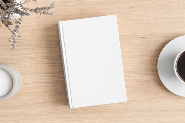 Foto mockup di libro bianco con una lavanda e una tazza di caffè sul tavolo di legno