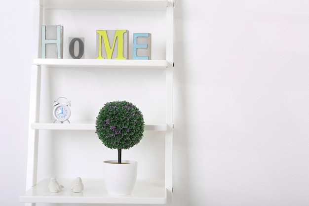 White bookcase with books and accessories in the room