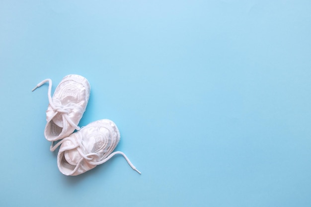 White booties on a blue background with copy space