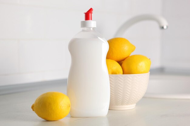 Photo a white bottle of dish soap next to a bowl of lemons.