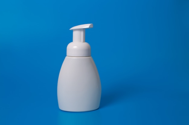 White bottle of liquid soap on a blue