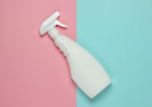 White bottle of spray for cleaning on a blue pink pastel background. Top view. Minimalism