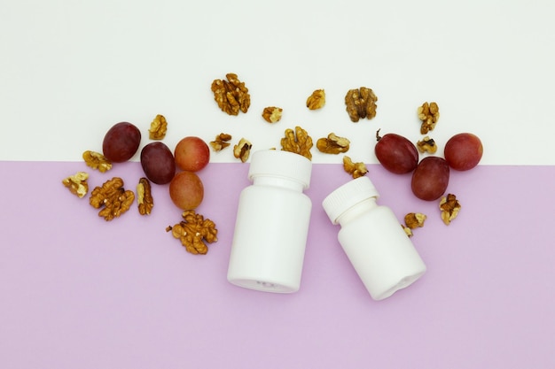 A white bottle of vitamins sits on a purple background with walnuts in the middle.