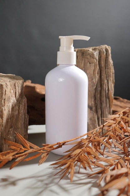 a white bottle of white soap sits on a table with a piece of wood in the background
