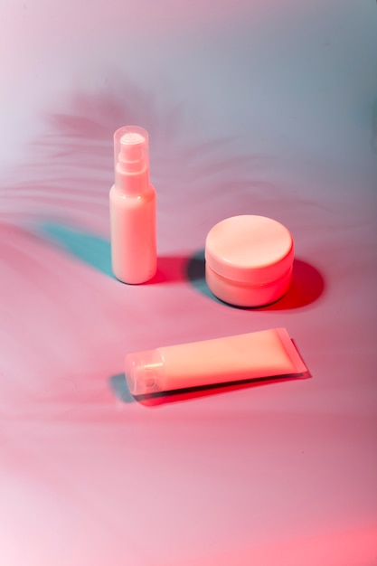 white bottles of cosmetics in neon