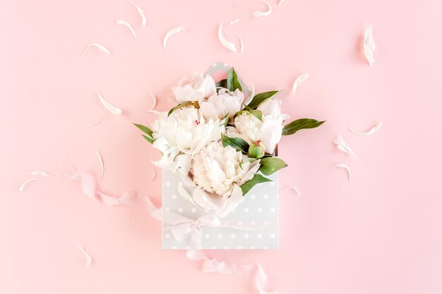 White bouquet of peonies in an envelope