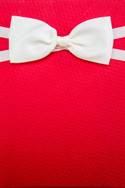 White bow tie on red gift box background