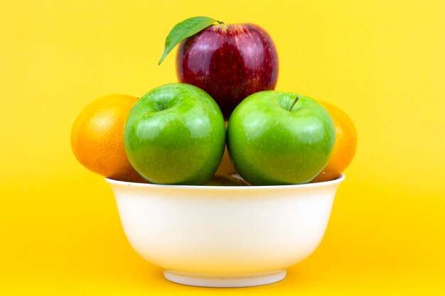 White bowl full of different healthy fruits green apples red apple oranges isolated