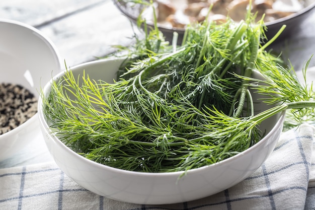 White bowl full of freshly picked dill.